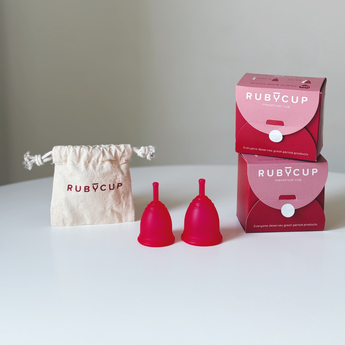 Ruby Cup menstrual cups in red with packaging and cotton bag