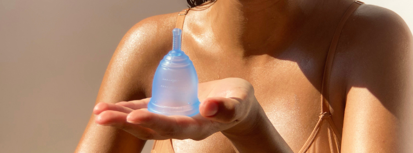 girl in bikini holding blue menstrual cup Ruby Cup