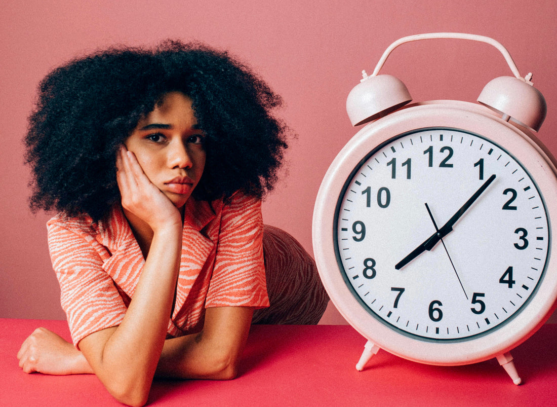 Woman looking bored next to a clock