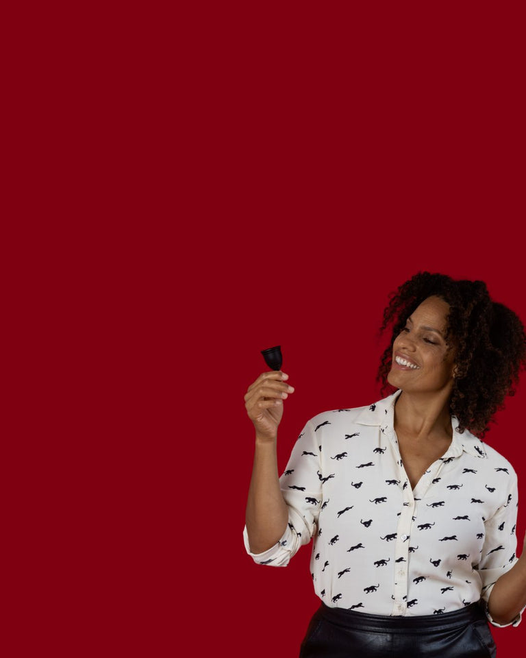 Woman holding a black Ruby Cup menstrual cup