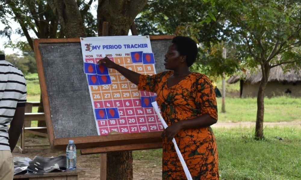 Woman next to a period tracker chart, part of the Me and My Cup Toolkit by Ruby Cup