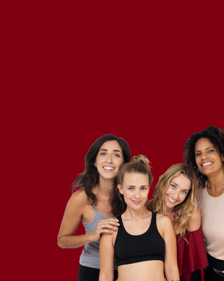 Four women standing together against a red background